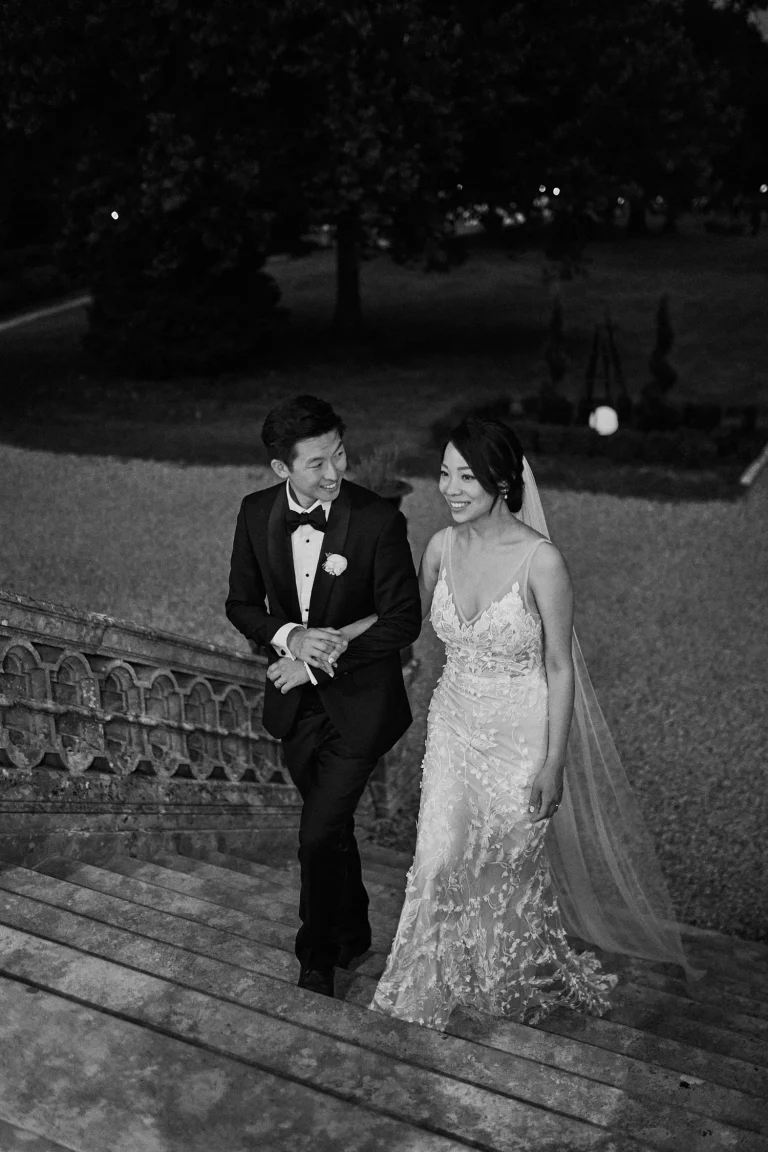 Newly wedded couple walking up on the Chateau stairs in black and white