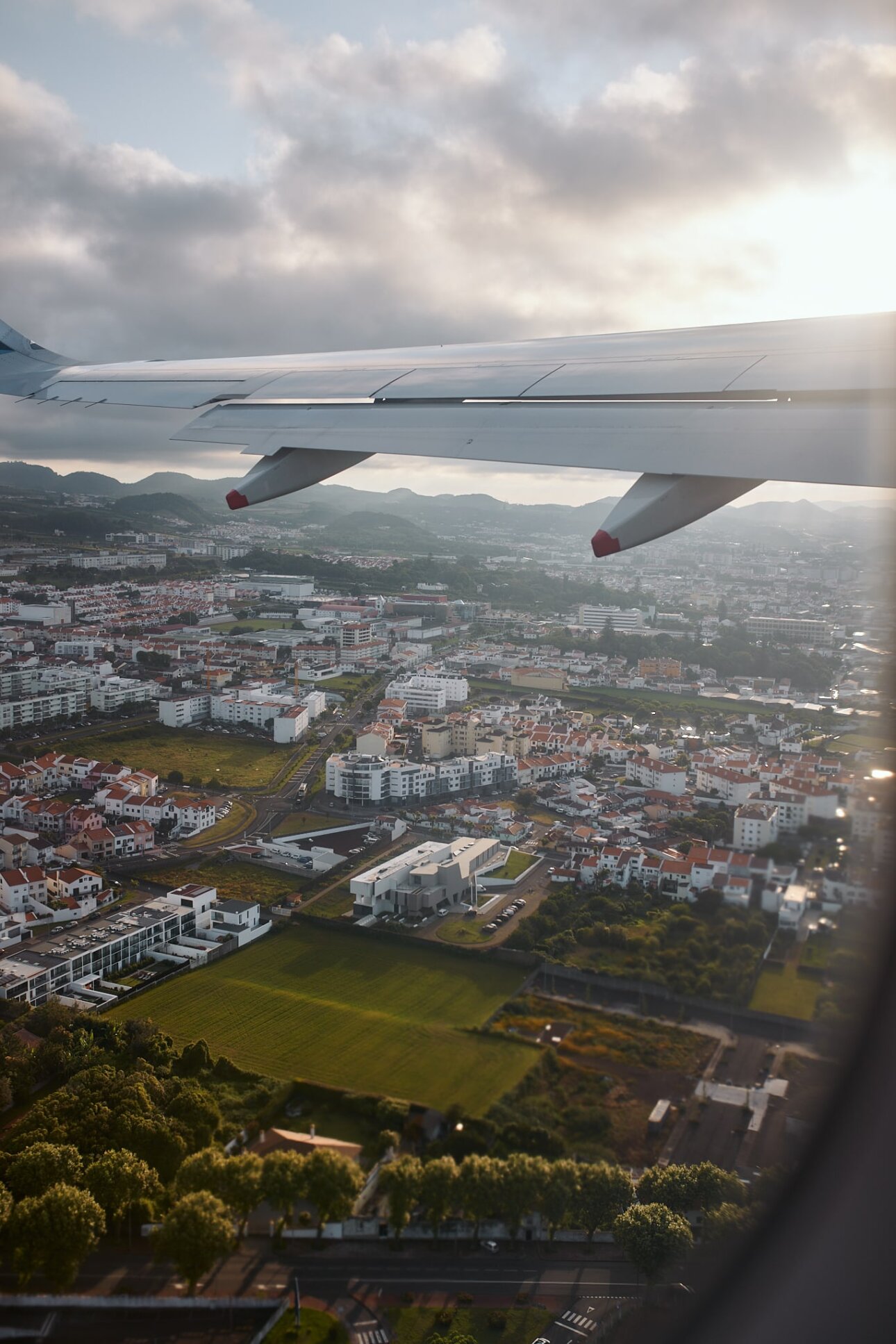 An airplane wing is seen from above the city.