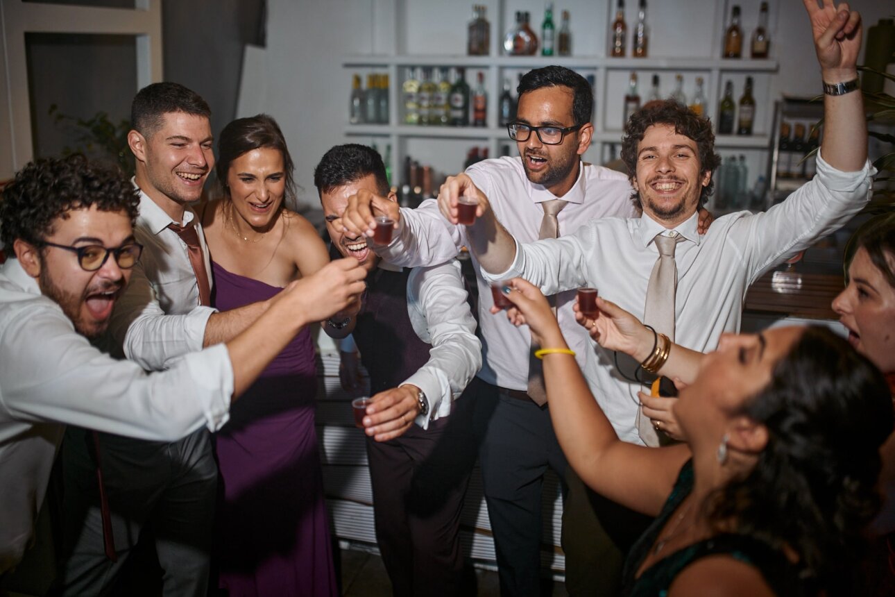 A group of people at a party with their hands up.